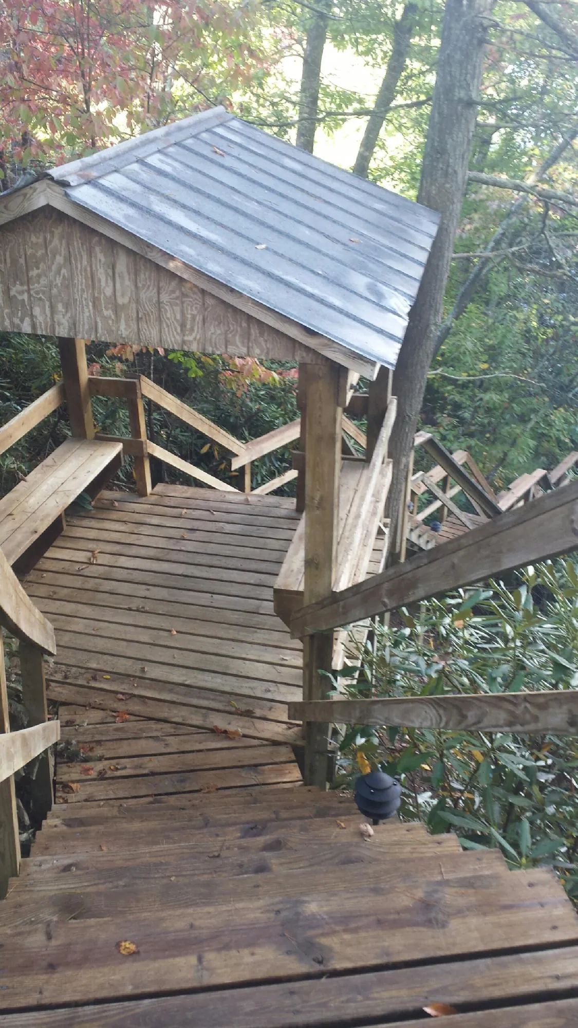Metal roofed shelter over wooden steps on a wooded walkway — Skylight Repair & Installation work by our crew in Addison